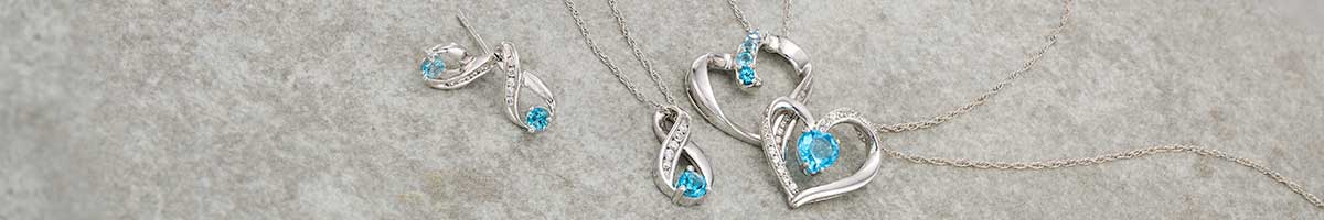 Stunning, brilliantly blue topaz inlaid in silver ribbon and heart shaped pendants